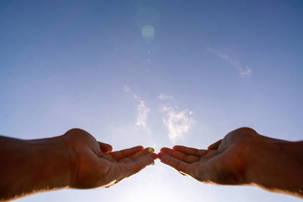 istock Blurred Hands praying for blessing from god on sun and clouds background with lens flare,Christian Religion concept. 1220460942
