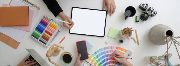 istock Top view of two designers working together with digital devices at comfortable workspace 1220474177