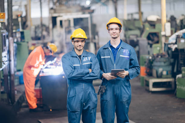 istock Smile Engineer And Apprentice standing in factory 1220482506