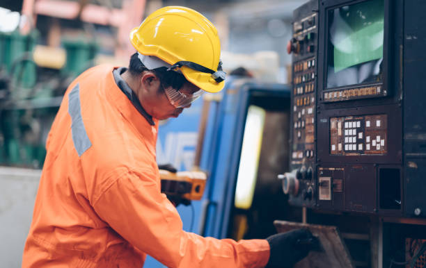 istock technician engineer and mentor control machine to automated CNC in factory 1220482541