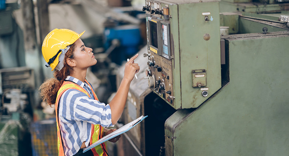 technician engineer women looking machine in factory