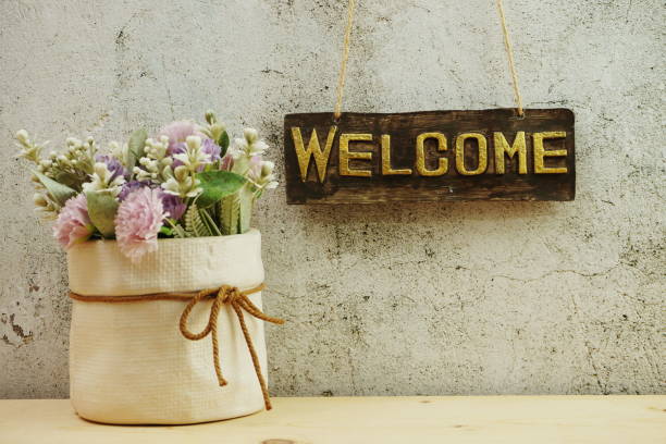 istock Welcome sign Hanging on grunge cement wall background 1220485573