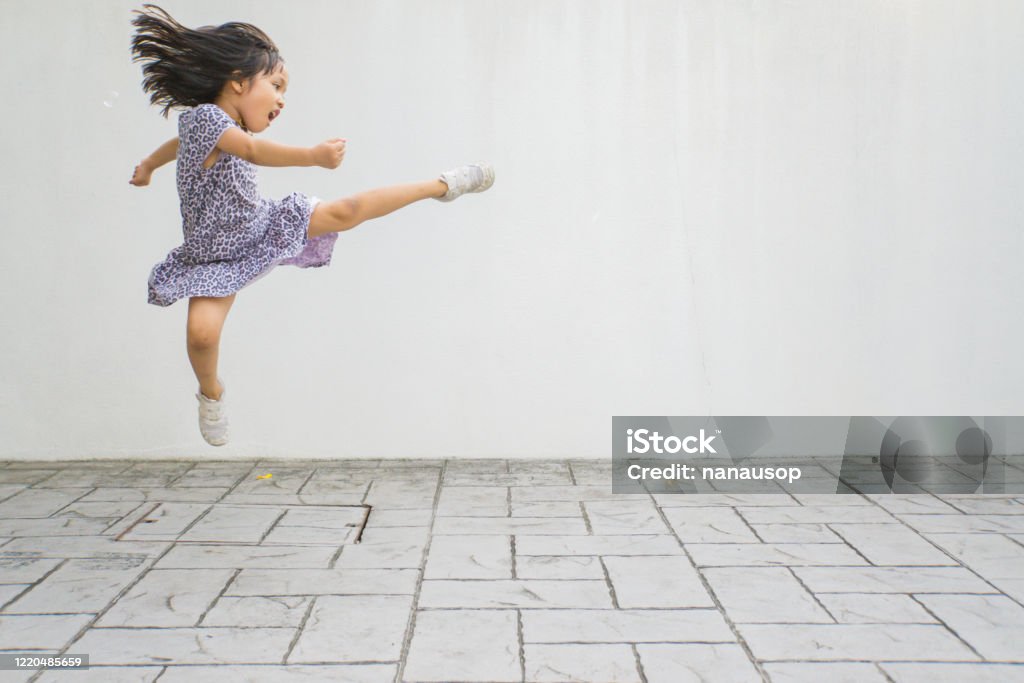 Funny little asian girl being playful during exercise session at home Funny little asian girl being playful during exercise session at home stock photo Strength Stock Photo