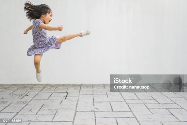 Funny Little Asian Girl Being Playful During Exercise Session At Home Stock Photo - Download Image Now