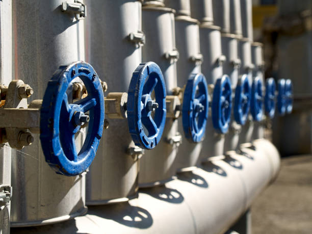 phantom blue industrial valves in a row on petrochemical plant pipelines system selective focus over out of focus background. - water valve oil gas imagens e fotografias de stock