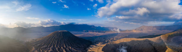 panorama-luftaufnahme des aktiven vulkans mount bromo und des cinderkegels des mount batok neben dem "meer aus sand" - cinder cone stock-fotos und bilder