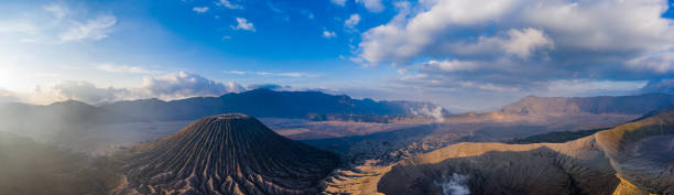 panoramiczny widok z lotu ptaka na aktywny wulkan mount bromo i stożek żużlowy mount batok obok "morza piasku" - bromo crater zdjęcia i obrazy z banku zdjęć