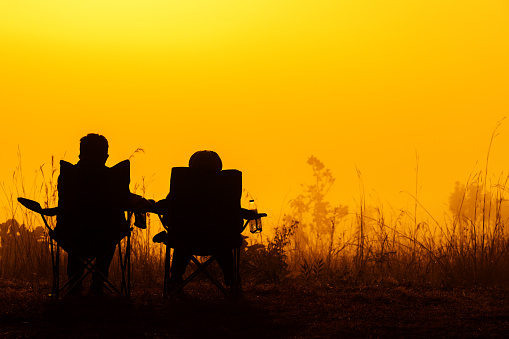 Picture of silhouette couple lovers watching sunrise among fog