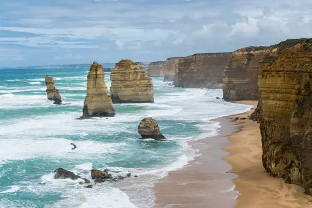 Photo of the twelve apostles limestone rock formations and the sea on a cloudy day