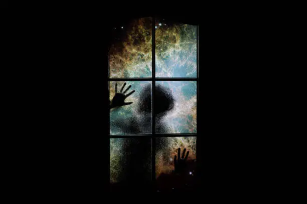 Photo of Soul in outer space with nebula and many stars behind closed door. Ð¡hild locked in dark room in nightmare. Astral body locked up. Abstract image of psychology. Elements of this image furnished by NASA