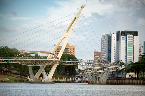 Kuching, Malaysia, January 4, 2019: Darul Hana spectacular pedestrian bridge is built to resemble the letter S (for Sarawak), and the two towers are designed to look like the hornbill-inspired structures of traditional bamboo bridges