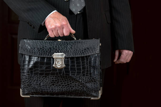 istock Old shabby leather briefcase in a businessmans hand 1220497382