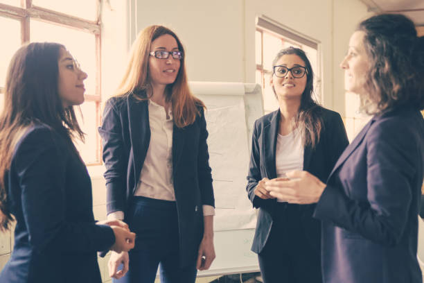 istock Confident mature employee talking with younger workers 1220498375