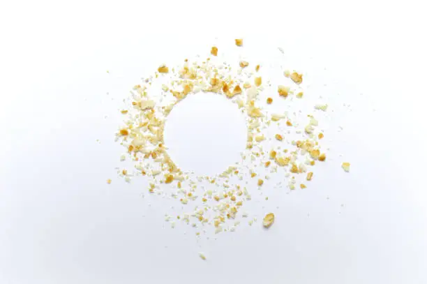 Scattered crumbs of cookies on white background. Copy space.