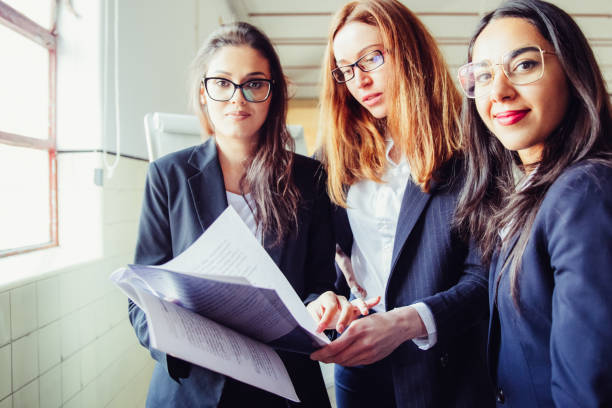 istock Group of smiling women with paper documents 1220499296