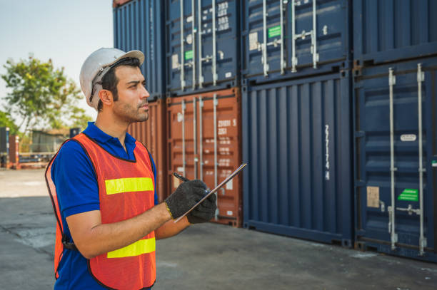 istock Foreman holding clipboard working at Container cargo harbor. Business Logistics import export shipping concept. 1220500188