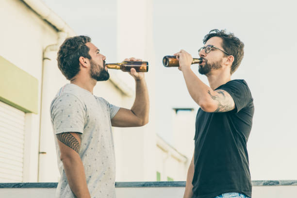 istock Side view of two handsome young man drinking beer 1220500213