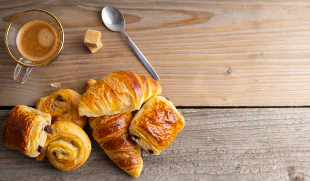 istock Breakfast table with croissants and cinnamon buns with fresh orange juice. 1220501395