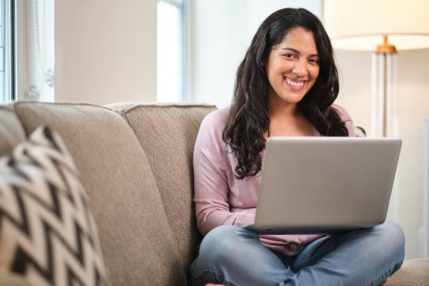 istock Pretty latin girl using laptop computer at home 1220501404