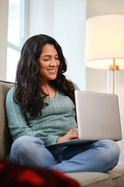 istock Pretty latin girl using laptop computer at home 1220501733
