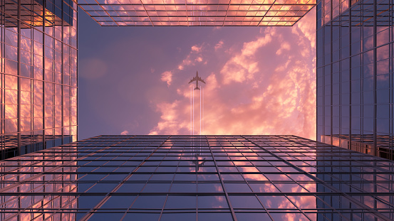 The plane flies over the skyscrapers. Wonderful 4k composition with sunset