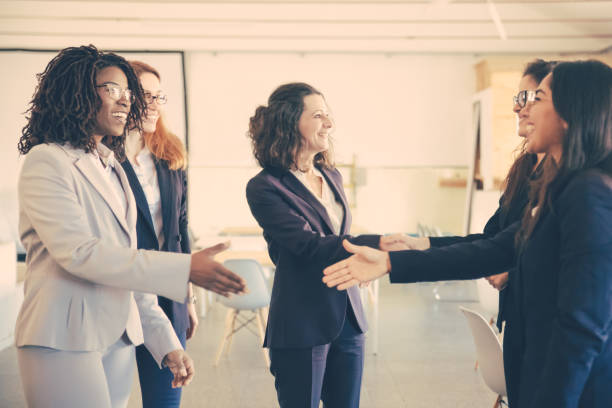 istock Smiling businesswomen shaking hands in office 1220503167