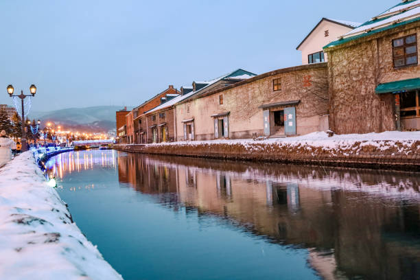 Otaru, Hokkaido, Japan - December 2019 : Otaru Canal in Winter with twilight light. One of Beautiful scene in Otaru canal with old warehouses. It is a popular tourist attraction of Hokkaido, Japan.