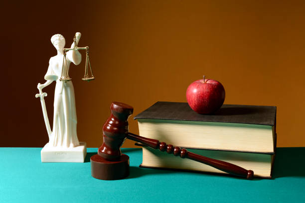 istock Books, a judge's hammer and a stone figure 1220505473