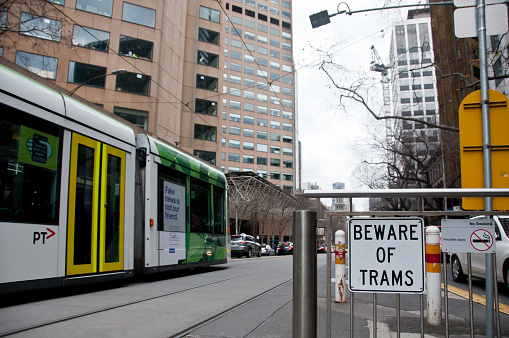 Melbourne, Australia - July 26, 2018: Beware of Tram sign with Melbourne tram in Melbourne Victoria Australia. There is nobody in the photo. The photo is taken in the afternoon