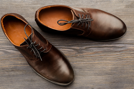 Fashionable men's classic brown shoes on a wooden background - image