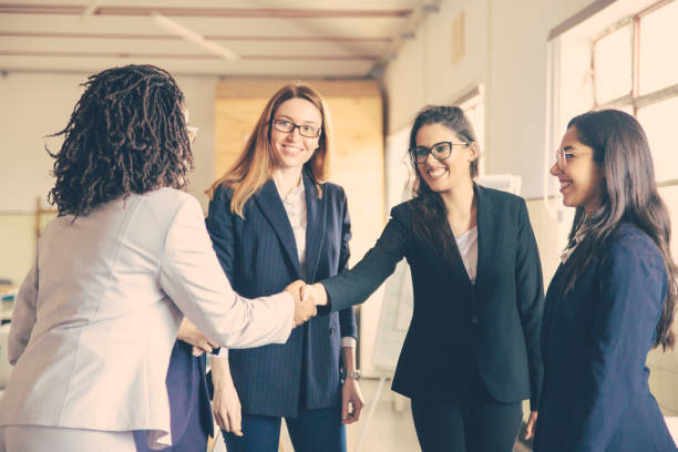istock Smiling young businesswomen shaking hands in office 1220509525