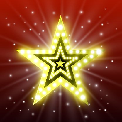 Golden vintage star with light bulbs and bright light on a red background. Retro star.