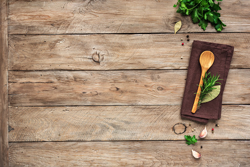 Herbs and spices with wooden spoon on wooden background. Cooking and healthy eating concept, top view, copy spce.