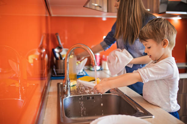 istock Mother and little son doing the dishes together 1220512177
