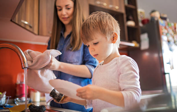 istock Mother and cute son doing the dishes together 1220512478