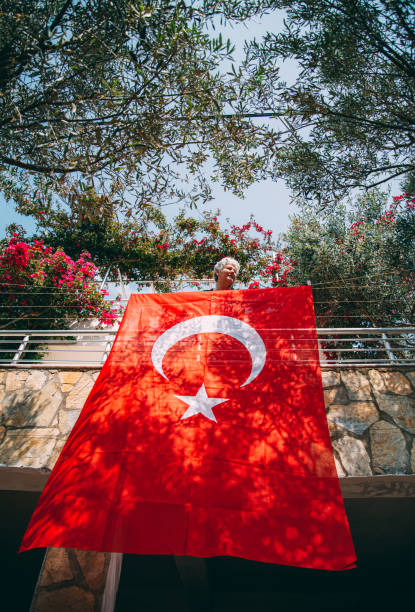 istock Woman Hanging a Turkish Flag on her Balcony 1220512520