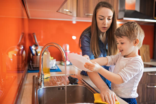 istock Mother and adorable son doing the dishes together 1220513095