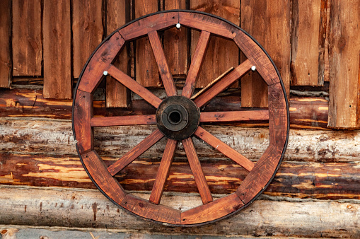 wooden cart wheel on the wall of a wooden house