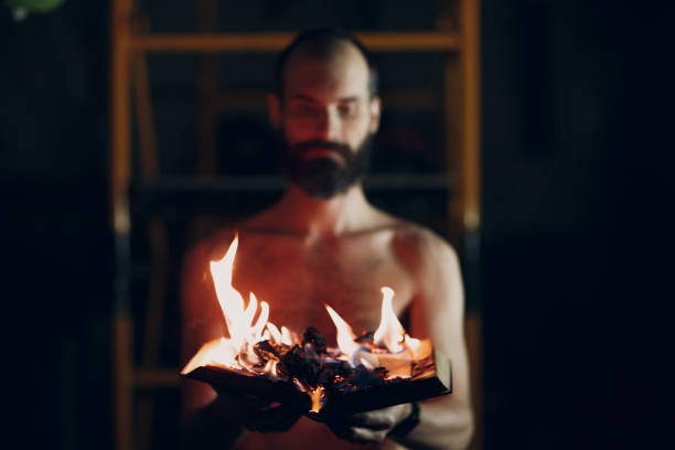 istock Man holds burning book in his hands. 1220515294