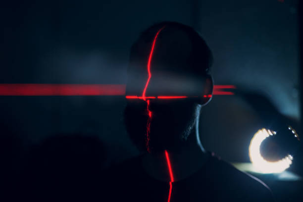 istock Man in dark with face illuminated by red laser on contour 1220515337