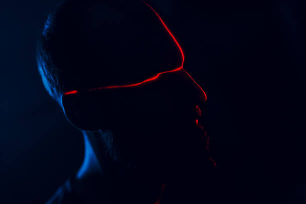 istock Man in dark with face illuminated by red laser on contour 1220515342