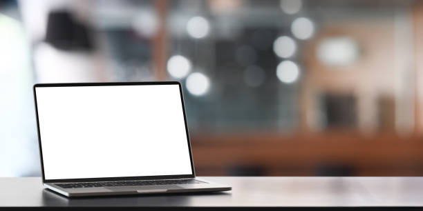 istock Computer laptop with white black screen putting on counter bar over blurred office as background. 1220515713