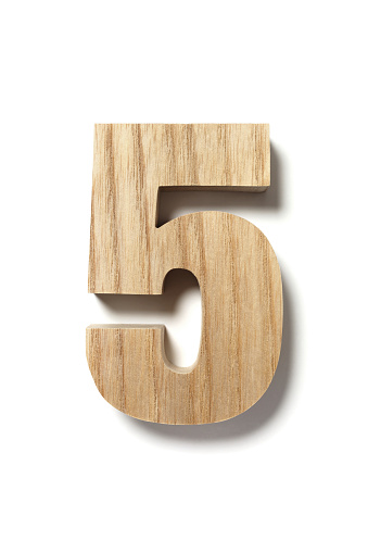 Number Five cut out from a piece of wood , isolated on white background.