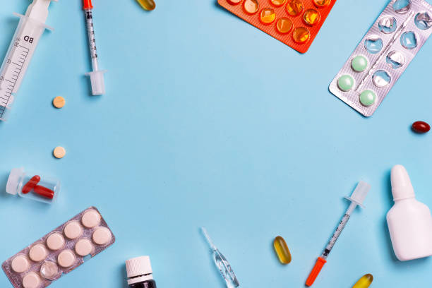 istock Medical backdrop with different treatments, tablets, pills and plastic syringes on a light blue background. 1220518502