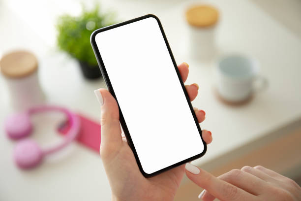 istock female hands holding phone with isolated screen in room 1220518572
