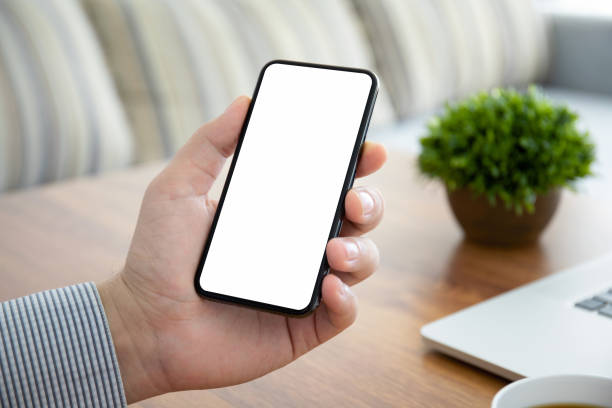 istock male hand holding phone with isolated screen in the office 1220518972