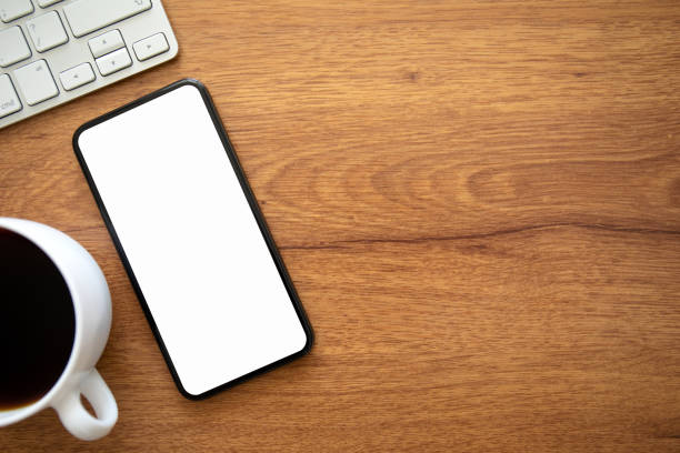 istock phone with isolated screen table keyboard and cup of coffee 1220519860