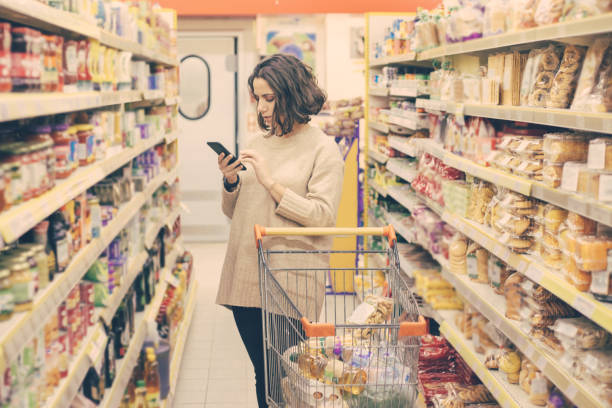 istock Woman with smartphone choosing goods in store 1220522004