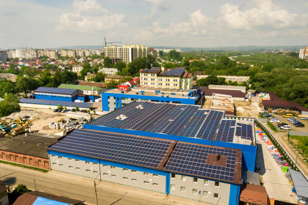 aerial view of many photo voltaic solar panels mounted of industrial building roof. - voltaic imagens e fotografias de stock