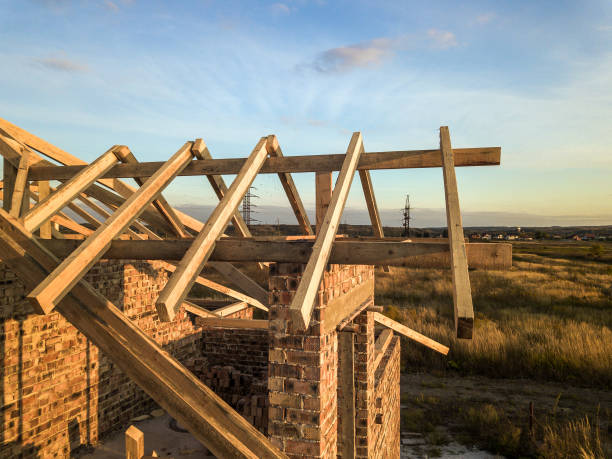 istock Private residential house with wooden roof frame structure under construction. Unfinished brick building under development. 1220526543